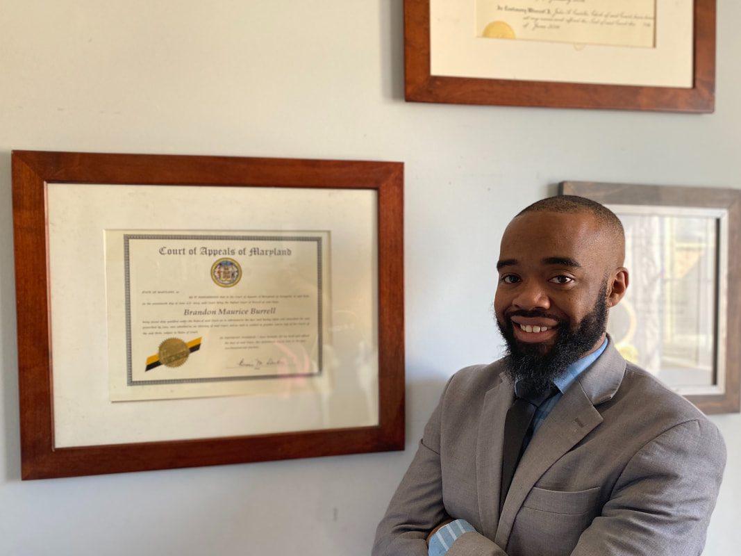 Brandon M. Burrell, Esq. in his office, beside his certificate of admission to the Court of Appeals of Maryland